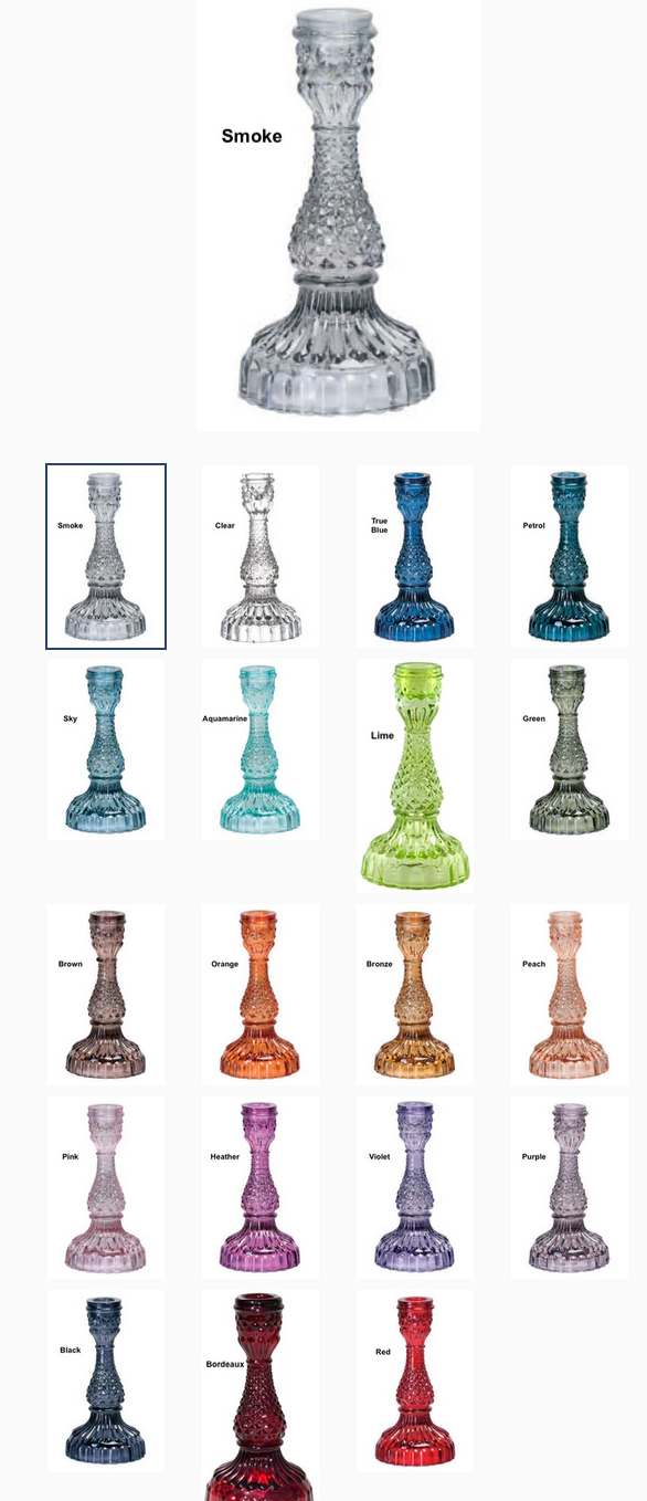 Collection of various colored glass candle holders on a white background