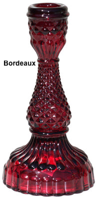 A collection of Bella Candle Holders in various colors. These vintage-inspired glass holders have a pressed and lacquered design, standing 4 inches wide by 8.