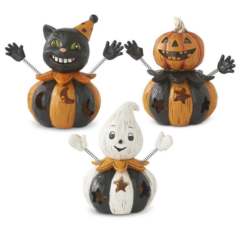 Three Halloween-themed pumpkin figurines on a white background