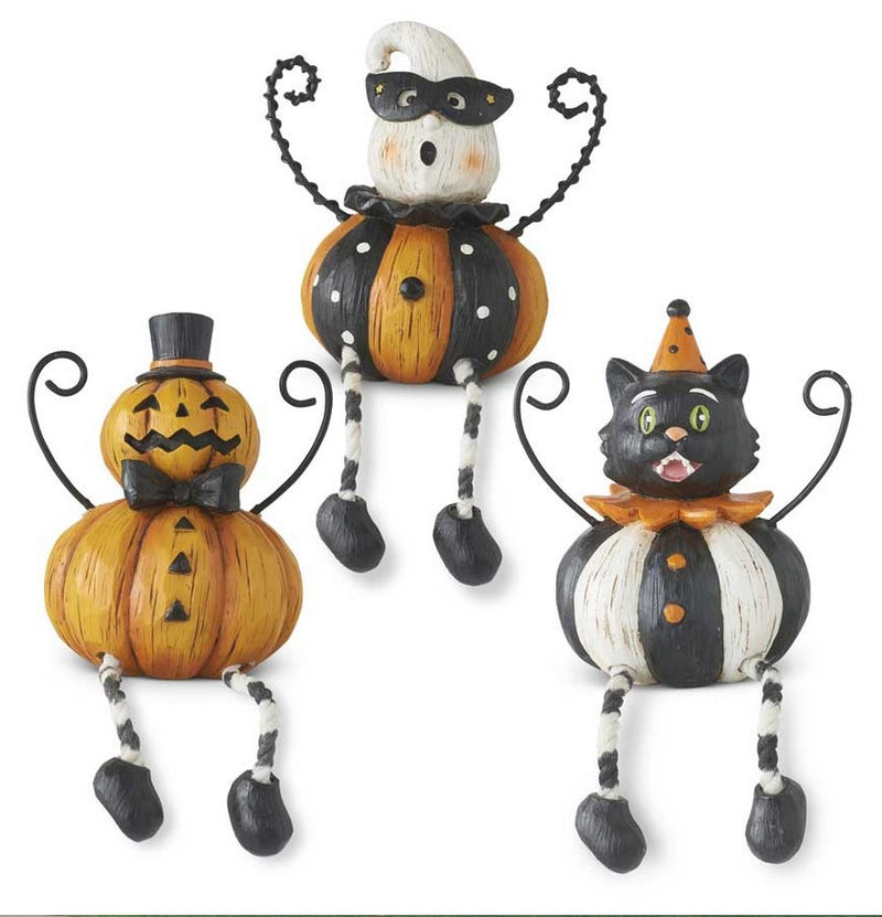 Three Halloween-themed pumpkin figurines with black and white accents on a white background