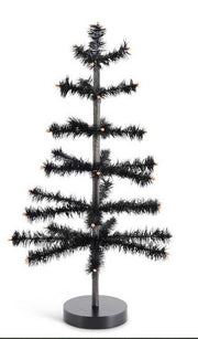 Black artificial Christmas tree with lights on a white background