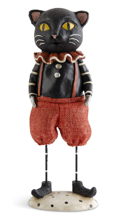 Cat figurine wearing a jacket and red pants on a white background