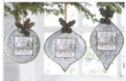 Three decorative Christmas ornaments hanging from a tree branch.