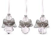 Three angel-shaped ornaments with crystal bodies on a white background