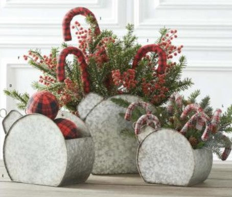 Decorative Christmas arrangement with candy canes, berries, and plaid balls in metal planters.