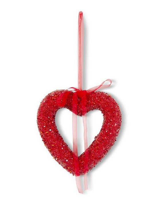Red heart-shaped decoration with a pink stick on a white background