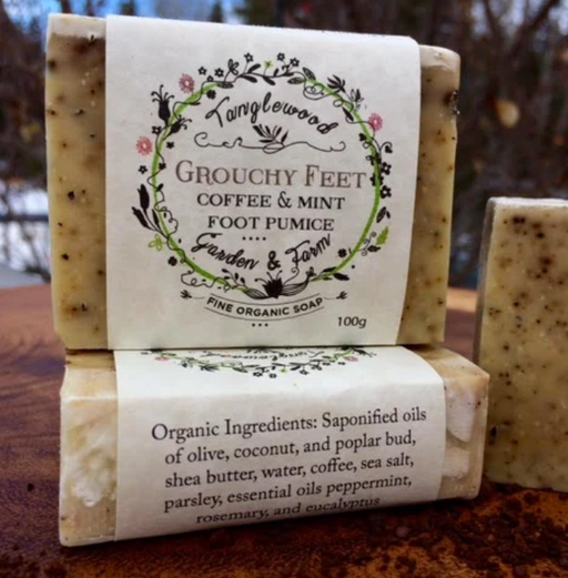 Two bars of soap with labels on a wooden surface