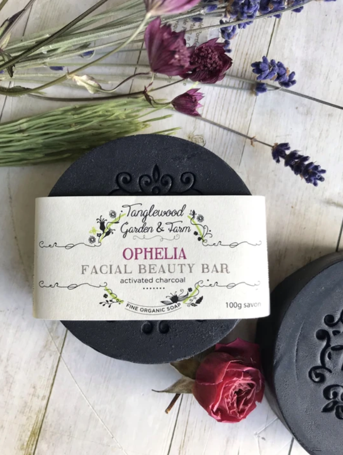 Facial beauty bar with 'Ophelia' branding on a wooden surface with flowers.