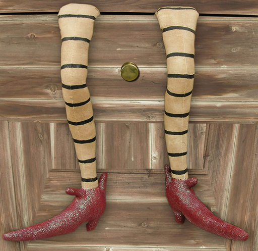 Pair of striped legs with red shoes on a wooden surface