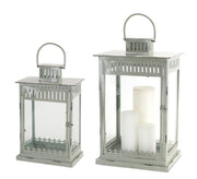 Two silver lanterns with white candles on a white background