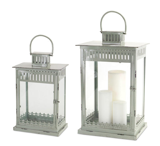 Two silver lanterns with white candles on a white background