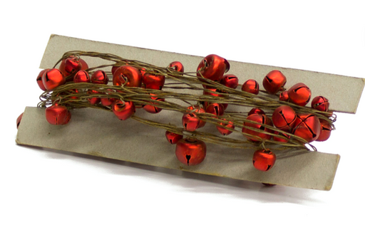 Red jingle bells on a wooden board with a white background