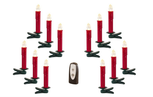 Set of red candles with green holders and a remote control on a white background