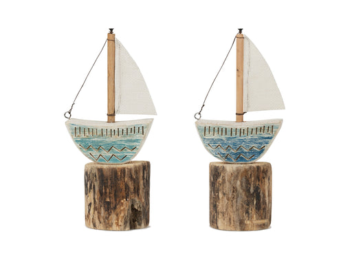 Two decorative sailboats on wooden stands with a white background