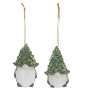 Two Christmas-themed gnomes with tree hats hanging on a white background