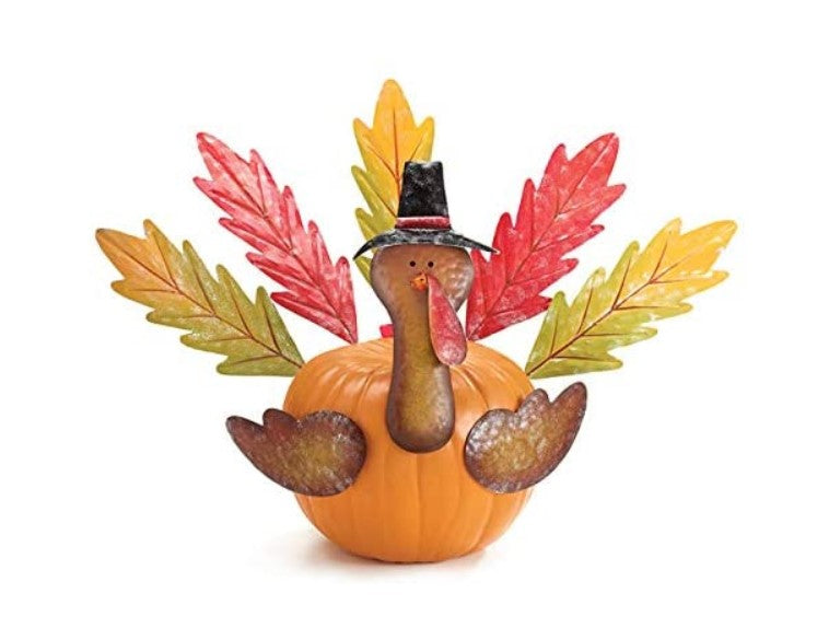Decorative Thanksgiving turkey figure with a pumpkin base and autumn leaves on a white background