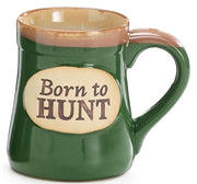 Green mug with 'Born to Hunt' text on a beige background
