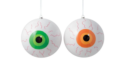 Two eyeball-shaped ornaments with green and orange irises on a white background