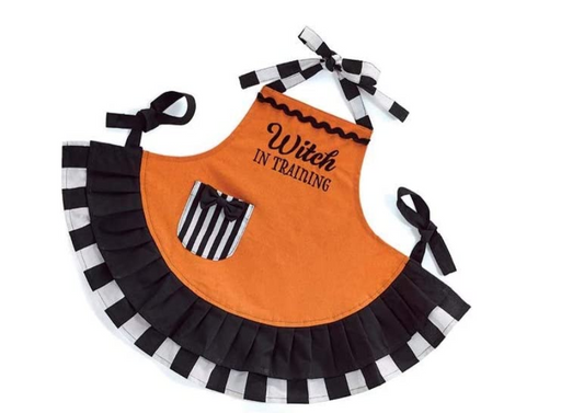 Halloween-themed apron with 'Witch in Training' text on an orange background