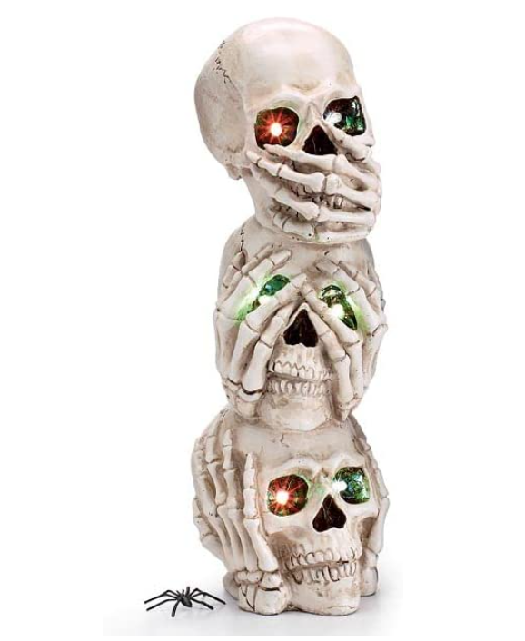 Stack of three skeleton heads with glowing eyes on a white background