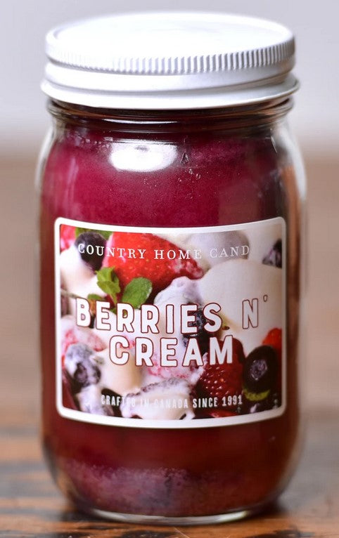Jar of 'Berries N' Cream' candle with a label on a wooden surface