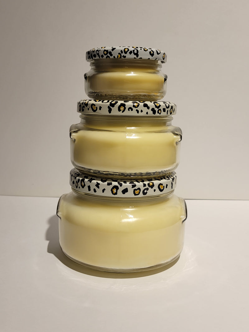 Stack of glass jars with leopard print lids on a white background