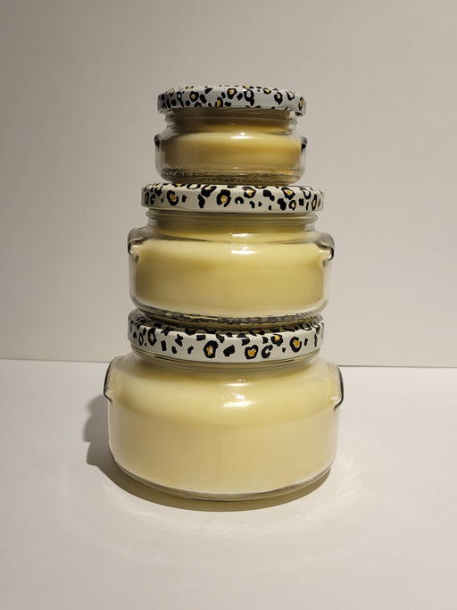 Stack of glass jars with leopard print lids on a white background