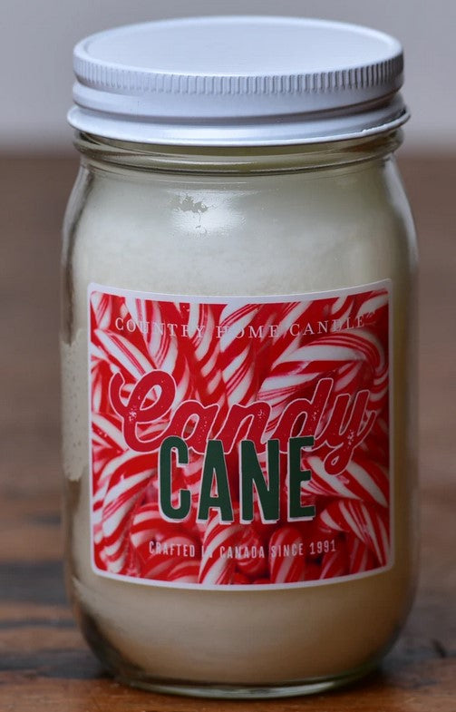 A jar of Candy Cane scented candle with a white lid and a label that has red and white stripes and text.