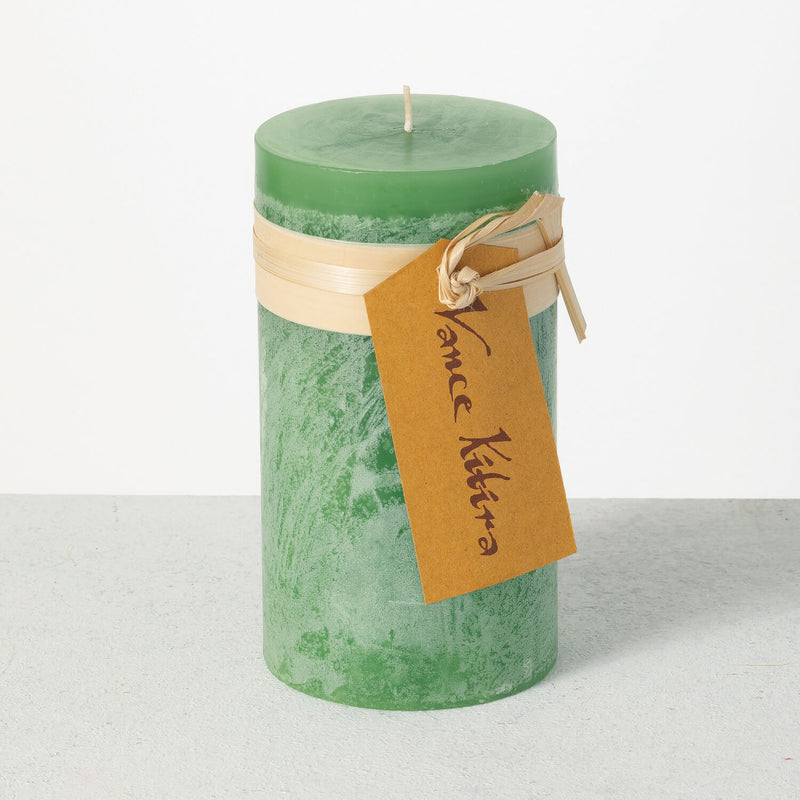 Green candle with a brown tag on a white background