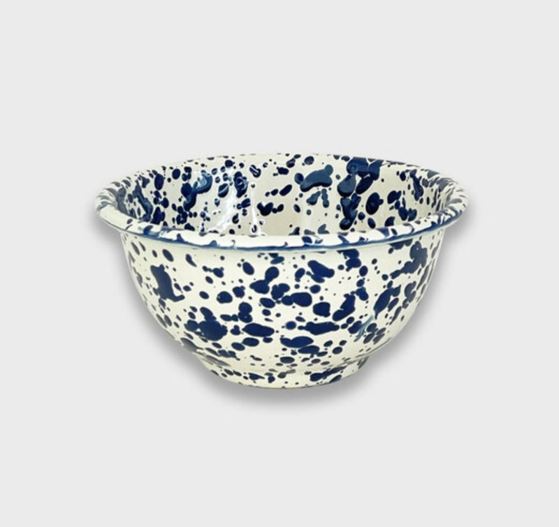 A small footed bowl with a white and blue splatter pattern design.