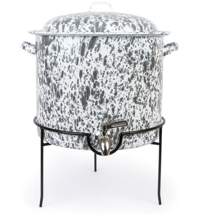 A grey and white speckled enamelware beverage dispenser with a metal rack.