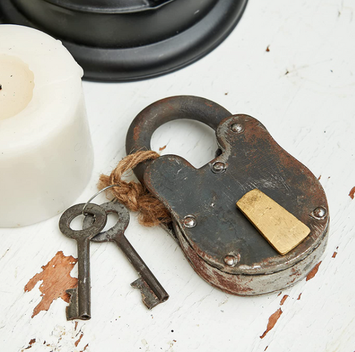 Vintage-style padlock with keys on a textured surface