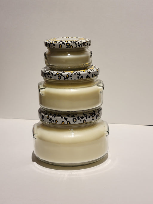 Stack of glass jars with leopard print lids on a neutral background