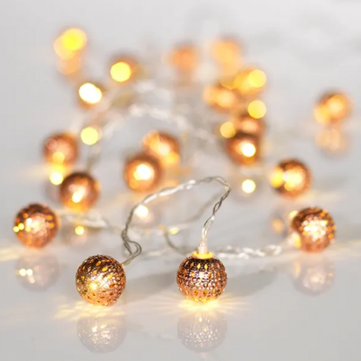String of decorative lights with gold spherical bulbs on a white background