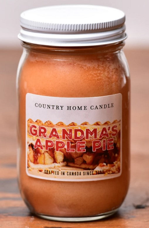 Jar of 'Grandma's Apple Pie' candle with a label on a wooden surface