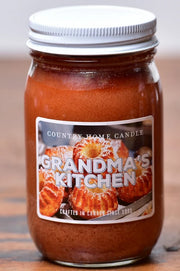 Jar of 'Grandma's Kitchen' candle with a label on a wooden surface