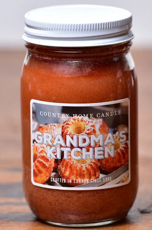 Jar of 'Grandma's Kitchen' candle with a label on a wooden surface