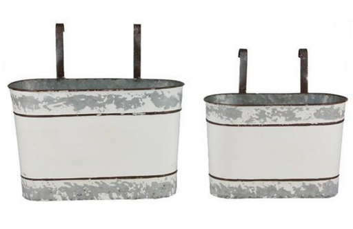 Two metal planters with distressed white finish and black handles on a white background