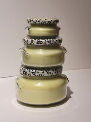 Stack of ceramic jars with leopard print lids on a white background