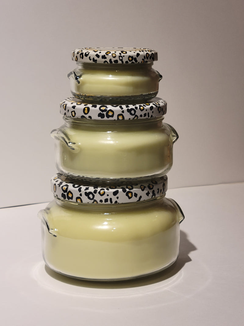 Stack of ceramic jars with leopard print lids on a white background
