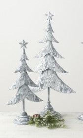 Decorative Christmas trees with silver and white finishes on a light background