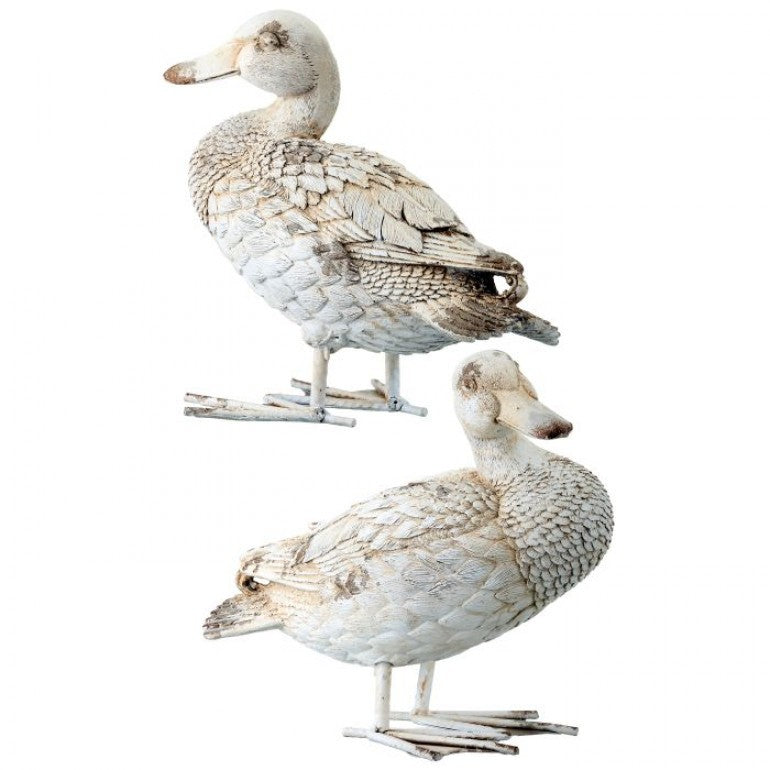 Two white duck decoys on a white background