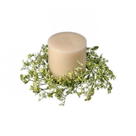 Beige candle with greenery on a white background