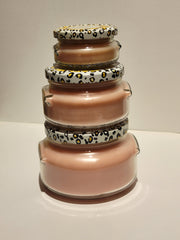 Stack of glass jars with patterned lids on a white surface