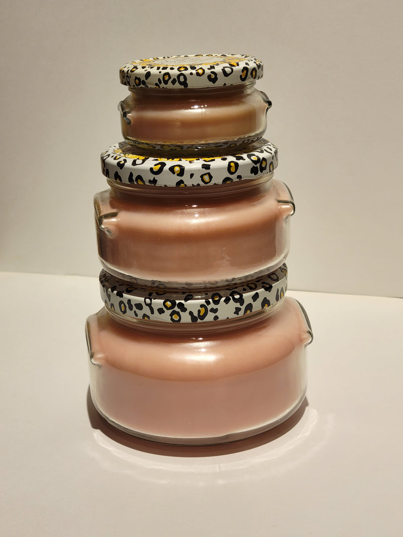 Stack of glass jars with patterned lids on a white surface