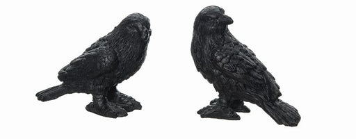 Two black crow figurines on a white background