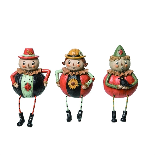 Three colorful pumpkin figurines with hats and outfits on a white background