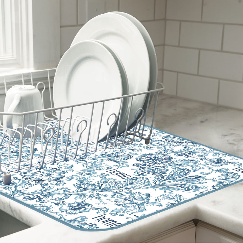 Dish rack with plates on a floral-patterned mat in a kitchen
