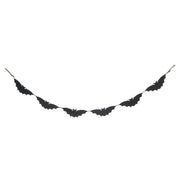 Black bat-shaped decorative item on a white background