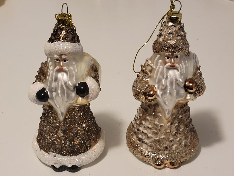 Two decorative Santa Claus ornaments with glittery textures on a white background